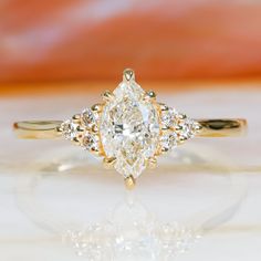 a yellow gold engagement ring with a pear shaped diamond