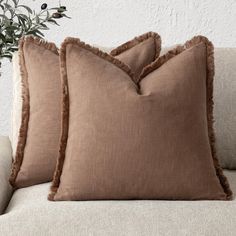 two brown pillows sitting on top of a couch