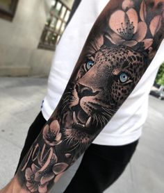 a man with a leopard and flowers tattoo on his arm