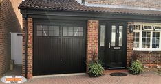 a brick house with two black garage doors