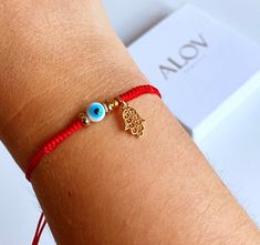 This listing is for one braided red string bracelet with a round evil eye bead, two gold plated bead spacers and gold plated hamsa hand charm.  -Sliding knot closure that makes it ajustable. -You can choose with or without hamsa hand charm.  Feel free to contact me if you want to customize it by adding more charms or beads. These are handmade to order. Includes a card stock with a jewelry box ready for gifting as you can see in the last picture. ----------------------------------------------- GI Round Evil Eye, Sliding Knot Closure, Hamsa Bracelet, Red String Bracelet, Red String, Protection Bracelet, Sliding Knot, Eye Bracelet, String Bracelet