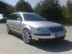 a silver car parked in front of a bridge