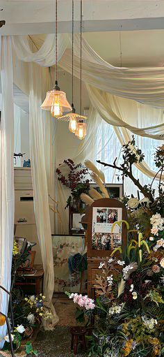 a room filled with lots of different types of flowers and plants hanging from the ceiling