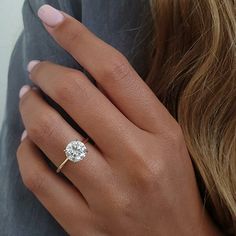 a woman's hand with a diamond ring on it