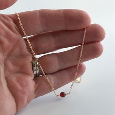 This genuine garnet gemstone necklace features a dainty 5mm faceted gemstone. The stone is a beautiful deep red color. This garnet necklace is available on your choice of 14k gold filled, 14k rose gold filled or sterling silver chain. Lengths for this dainty necklace are available from a petite 15 inches to 18 inches. The recommended length for most women is 16 inches. Garnet is the January birthstone. The perfect gift for her, this gold necklace will arrive in a gift box. More garnet jewelry ht Minimalist Red Gemstone Birthstone Necklace, Garnet Gemstone Beads Jewelry As A Gift, Garnet Gemstone Beads Jewelry For Gifts, Dainty Garnet Necklace For Gift, Elegant Amber Birthstone Necklace For Gift, Faceted Carnelian Jewelry Gift, Red Minimalist Birthstone Necklace, Dainty Garnet Jewelry For Gifts, Amber Birthstone Dainty Necklace