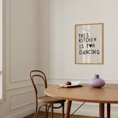 a table with two chairs and a vase on it