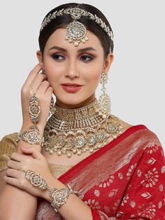 This jewelry set consists of a necklace, a pair of earrings, 2 hathphool bracelets and matha pattiGold-plated necklace has white kundan-studded and white pearls beaded detailsSecured with a drawstring closureA pair of matching drop earrings, each secured with a post-and-back closure2 matching hathphool bracelets, secured with a s-hook closureA matching Matha patti, secured with a hook closure Size & Fit Size of the necklace: 24 cm x 12 cm (Length x Width)Size of the earrings: 11 cm x 5.5 cm(Length x Width)Size of the Mathapatti: 11 cm x 23.5 cm(Length x Width)Size of the Hathphool: 13 cm x 16 cm (Length x Width) Material & Care Material: AlloyPlating: Gold-platedStone Type: Kundan and Beads Care InstructionsWipe your jewellery with a soft cloth after every useAlways store your jewellery in Luxury Festive Jewelry Sets With Latkans, Luxury Cutdana Tikka For Reception, Adjustable Kundan Jewelry For Weddings, Adjustable Kundan Necklace For Puja And Festive Occasions, White Chandbali Bridal Sets For Ceremonies, Festive Adjustable Kundan Necklace For Puja, White Hand Set Temple Jewelry Sets, Festive Adjustable Kundan Necklace With Tilla, Kundan Necklace With Stone Work For Rituals