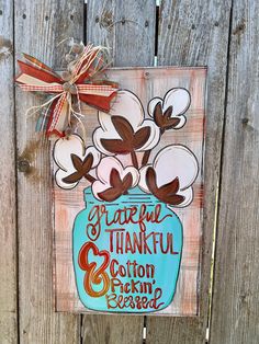 a wooden sign with flowers in a mason jar on it that says grateful and thank