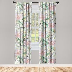 an open window with floral curtains and wooden flooring in front of the window is a white