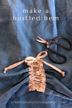 a pair of scissors sitting on top of a piece of fabric with the words make a busted hem