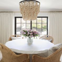 a dining room table with chairs and a chandelier hanging from it's ceiling