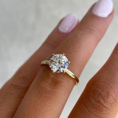 a woman's hand with a diamond ring on it