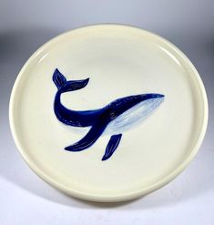 a blue and white plate with a whale painted on it