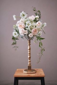 a vase filled with flowers sitting on top of a wooden table