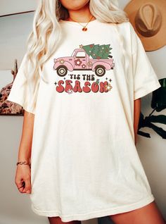 This retro Custom Colors Pink Truck Christmas Tis the Season shirt is the perfect  top for holiday season for truck lovers, drivers, and passengers everywhere. The shirt will also make a great gift for your bestie, friend, sister, brother, co-worker, teacher, mechanic and anyone who loves vintage trucks...the color pink... and Christmas - but not necessarily all three! Great for an oversized look. Unisex for women and men. DESCRIPTION * Our shirts are soft and comfortable and the styling possibilities are endless. Roll up the sleeves, tie a side knot, front tuck, or wear it while lounging around the house. * Comfort Colors is a garment-dyed t-shirt made with 100%  ring-spun cotton.  * Soft-washed, garment-dyed fabric brings extra coziness to your wardrobe while the relaxed fit makes it an Bestie Holiday, Family Holiday Pajamas, Pink Truck, Front Tuck, Christmas Truck, Vintage Trucks, Boho Vintage, Vintage Women, Sister Brother