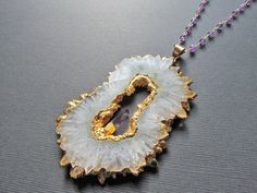 This listing is for one White Quartz and Amethyst Necklace. This stunning piece is absolutely HUGE!This necklace is electroplated in gold and comes on a 30 inch wire wrapped amethyst and gold plated chain with a small accent amethyst crystal in the middle of the pendant.Pendant size with bail: 90mmx60mm ( 3 1/2 inches x 2 3/8 inches )I ship all additional items for free as long as they are paid for on the same invoice.Please check out my other listings for more Necklaces :https://www.etsy.com/sh Gold Amethyst Crystal Necklace With Natural Stones, Gold Amethyst Pendant Crystal Necklace, Unique Gold Crystal Necklaces With Stones, Gold Amethyst Jewelry With Stones, Gold Amethyst Gemstone Crystal Necklace, Unique Gold Amethyst Jewelry, Unique Gold Crystal Necklaces With Gemstone, Unique Amethyst Gold Jewelry, Unique Gold Crystal Necklace With Gemstone