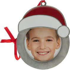 a christmas ornament with a boy wearing a santa hat