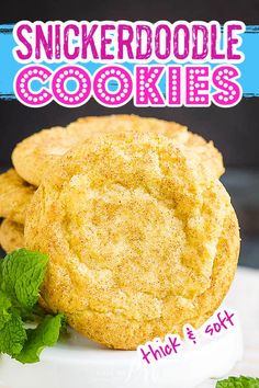 a stack of cookies on top of a white plate with mint sprig next to it