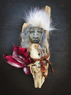 an image of a mask with feathers on it's head and other items around it