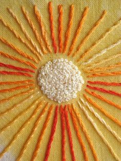 an orange and white sunburst made out of yarn