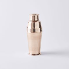 a copper colored vase sitting on top of a white table