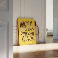 a yellow sign that says hell yes on it in front of a white wall and wooden floor