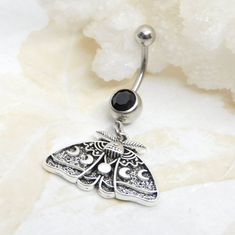 a silver belly ring with a black stone in the shape of a butterfly on it