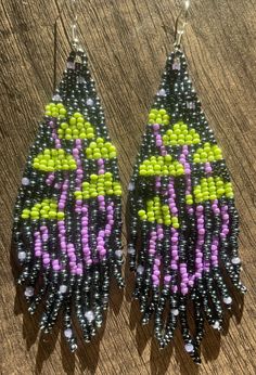 two pairs of beaded earrings on top of a wooden table