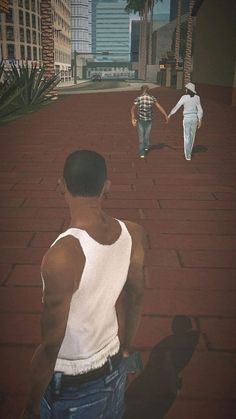 two men are walking down the street in front of some palm trees and tall buildings