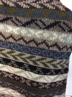 "Knitted poncho in ethnic motifs, similiar to fair isle knitting, but a world away. Made in Nepal. Pullover, no arm slits. Horizontal bands in browns, greys, blue, black and off white. Trimmed in grey fringes. Wool has some long fibres, so possibly some alpaca in the mix. There are no faults. No Label size , but I'd say it is small. The garments measurements are:- Across shoulders 20 12\" Chest, under arms 48\" Neck opening across 12\" Width across shoulders 18\" Length including fringes 20\" Sh Bohemian Knit Sweater With Fair Isle Pattern, Bohemian Knitted Patterns For Winter, Bohemian Fair Isle Knit Sweater, Multicolor Fair Isle Pattern For Winter, Bohemian Alpaca Sweater With Fair Isle Pattern, Bohemian Knit Patterns For Winter, Bohemian Winter Knit Patterns, Multicolor Hand Knitted Nordic Pattern, Winter Bohemian Knit Patterns