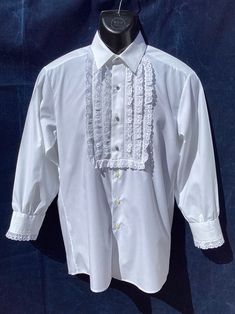 Authentic Vintage Spanish Shirt from Andalucia in Southern Spain Typical Style Equestrian Horse Riding/Flamenco Formal Dress Shirt Medium Size Chest 40"(101.5cm).   P to pit 20"(50.5cm) Sh to sh 17.5"(44.5cm) Collar 13"(33cm) Length from Nape to hem 30.5"(77.5cm) Sleeves fro Sh to cuff 21"(53cm).  P to cuff 17"(43cm) PLEASE CHECK ALL THE MEASUREMENTS OR IT MIGHT NOT FIT!! Good Quality White Shirt with Broderie Anglaise Cotton Lace cotton 33% polyester 67% Machine washable  Very Good Vintage Cond Classic Fitted Dress Shirt For Party, Fitted White Shirt With Ruffles, Formal Fitted Ruffle Tops, Fitted Ruffle Shirt Elegant Style, Classic Formal Shirt With Ruffles, Fitted Shirt With Spread Collar For Party, Classic Party Tops With Spread Collar, Formal White Ruffled Shirt, White Fitted Shirt For Party