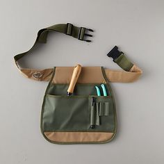 a green and tan pouch with two pens in it