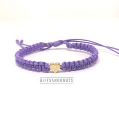 This bracelet is made of purple waterproof rope and a gold plated heart charm. Trendy Purple Braided Bracelet For Gift, Trendy Purple Braided Bracelet Gift, Gold Nylon Cord Friendship Bracelets As Gift, Handmade Gold Nylon Cord Friendship Bracelets, Handmade Gold Friendship Bracelets With Nylon Cord, Gold Heart Friendship Bracelets With Sliding Knot, Trendy Purple Friendship Bracelets As Gift, Casual Gold Waxed Cord Jewelry, Casual Purple Braided Bracelet As Gift