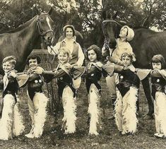 a group of children standing next to each other in front of a horse