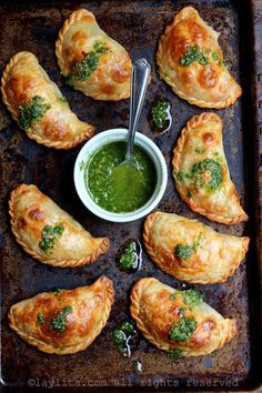 baked pastries on a baking sheet with dipping sauce