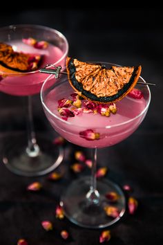 two glasses filled with pink drink and garnished with flowers