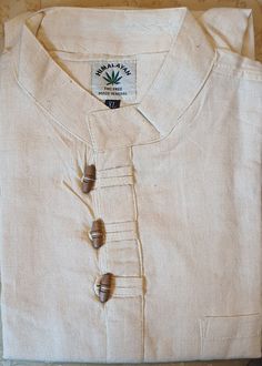 You are looking at full sleeve grandad Shirt/Kurta, with 3 hand carved wooden buttons  for casual, summer, festival,Yoga, beach use. Features:     ✔Colour: Cream/White    ✔Classic design    ✔Size Chart: Please look at 2nd picture    ✔Material:         1.Upto 40% Organic Hemp fibre         2.Upto 40% Sustainable Bamboo Fibre          3.Upto 20 % Cotton fibre    ✔3 Traditional handmade wooden buttons fitted    ✔High quality fabric    ✔High quality stitching 1.Hemp Fibre: Hemp fibre is sustainable fibre obtained from hemp plants mostly found in empty or barren lands in Asian countries.Normally, it grows without needing any care, water or pesticides. It helps to lower carbon footprints and also does not cause any damage to soil quality. 2.Bamboo Fibre: Speciality of Bamboo Fibre: ✔Very very so Hemp Fabric Clothing, Casual Long Sleeve Beige Kurta, Casual Beige Long Sleeve Kurta, Beige Long Sleeve Casual Kurta, Traditional Stand Collar Top With Buttons, Traditional Cotton Top With Stand Collar, Casual Cotton Kurta With Button Closure, Traditional Long Sleeve Shirt With Button Closure, Cotton Festival Tops With Buttons