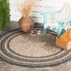 an outdoor area with a rug, chair and potted plant