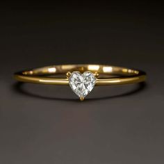 This sweet solitaire diamond ring features a lively 0.20ct heart shaped diamond. The diamond is bright white, completely eye clean, and vibrant with bold sparkle! The 14k yellow gold setting is utterly classic with a sleek, minimalist design. Utterly timeless in design with bright sparkle, this beautiful ring is an excellent choice for an enduring engagement ring, promise ring, or right hand ring.Graded G-H for color, the diamond is bright white. Graded VS2-SI1 for clarity, it is completely eye Heart-shaped Single Diamond Fine Jewelry Ring, Heart-shaped Diamond Ring With Single Stone, Heart Shaped Diamond Ring With Single Diamond, Valentine's Day Solitaire Diamond Ring, Gold Heart Ring With Single Diamond, Single Diamond Promise Ring For Valentine's Day, Dainty Heart-cut Diamond Ring, White Gold Heart Ring With Single Diamond For Gift, Heart Ring With Single Diamond Round Cut As Gift