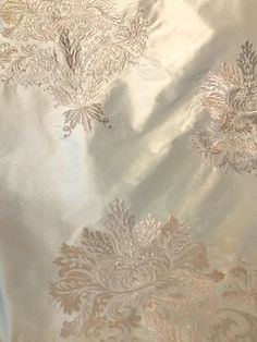 a white table cloth with gold and silver designs on it