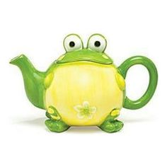 a green frog teapot with eyes and a flower on it's belly, sitting in front of a white background