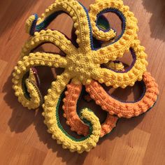 an octopus made out of crochet sits on the floor