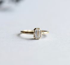 Simple and classic faceted emerald cut moissanite set on 14k yellow gold ring. Charles and Colvard moissanite stone. Comes with Forever One Charles and Colvard authenticity/warranty card Stone Shape: Emerald Metal type: 14 Karat gold Cut: Step-cut Color: GHI Carat weight: 0.5 ct Stone hardness: 9.25/10 Approx 1.6mm band width Stone size: 4mm x 6mm Radiant-Cut Moissanite: https://www.etsy.com/listing/1008204719/forever-one-radiant-emerald-cut?ref=shop_home_active_1&frs=1 Cubic Zirconia: https 14k Gold Diamond Ring With Radiant Rose Cut, Yellow Gold Solitaire Moissanite Emerald Ring, Yellow Gold Moissanite Solitaire Emerald Ring, Emerald Cut Emerald Ring With Rose Cut Diamonds, Heirloom Emerald Cut 14k Gold Wedding Ring, Moissanite Emerald Ring With Diamond Cut, Emerald Ring In 14k Yellow Gold With Square Cut, 14k Gold Emerald Ring With Diamond For Wedding, 14k Gold Emerald Cut Emerald Ring With Single Diamond