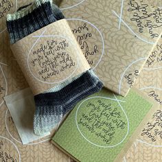 two wrapped gifts sitting next to each other on top of a table with writing on them