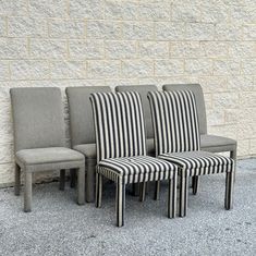 four striped chairs against a brick wall in front of a gray and black stripe chair