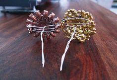 two brooches sitting on top of a wooden table