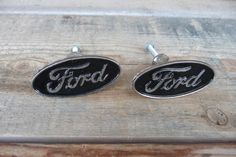 pair of ford emblem cufflinks on wooden table