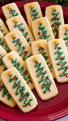 christmas cookies on a red plate decorated with green and red sprinkles are arranged in the shape of trees