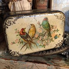 an old purse with birds painted on the front and sides, sitting on top of a table