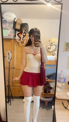 a woman taking a selfie in front of a mirror wearing white socks and a red dress